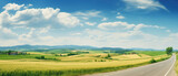 Fototapeta Fototapety z naturą - Beautiful summer rural natural landscape with fields young wheat, blue sky with clouds. Warm fresh morning and road stretching into distance. Panorama of spacious hilly area.