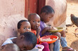 © poco_bw - group of village african children eating in the yard, famine and malnutrition NGO solving world problems