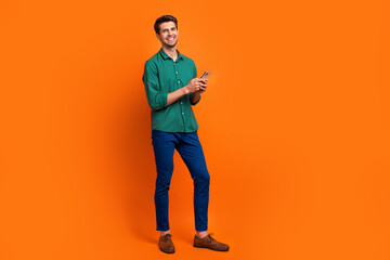 Aufkleber - Full length body photo of cheerful businessman instagram targetologist ceo director company with phone isolated over orange color background