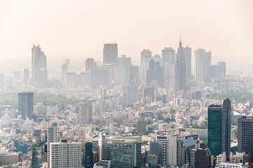  View from sky of Shinjuku buildings & skyscrapers, business district, in smog fog, Tokyo, Japan