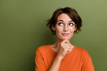 Poster - Portrait of charming business lady wearing orange t shirt touch chin looking copyspace decision isolated on khaki color background