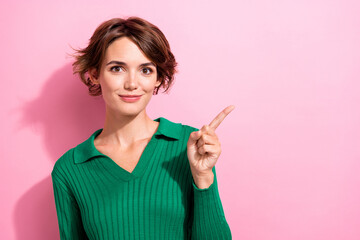 Poster - Photo of adorable cheerful girl with bob hairdo dressed green shirt indicating at benefit empty space isolated on pink color background