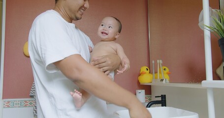 Poster - happy little cute Asian baby joy bathing and play water drop pouring into hand with father having fun smiling at bathroom, childcare childhood healthcare hygiene baby care