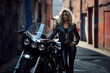 Biker girl. a woman in black standing on a motorcycle