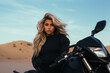 © GustavsMD - Woman with long white hair sitting near cross dirt motorcycle in desert. Girl are resting during off-road tour at hot desert