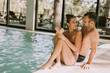 © BGStock72 - Young couple relaxing by the indoor swimming pool