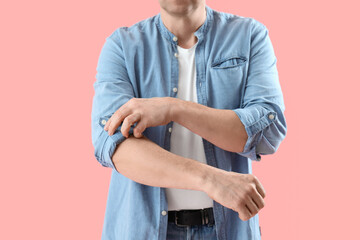 Wall Mural - Mature man rolling up his sleeve on pink background, closeup