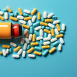 White and yellow medical pills are pouring out of a medicine bottle on a blue background.