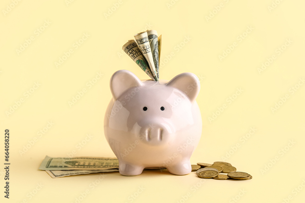 Piggy bank with money on beige background
