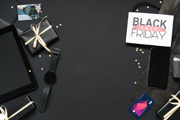 Sticker - Composition with Black Friday greeting card, gift boxes and gadgets on dark background