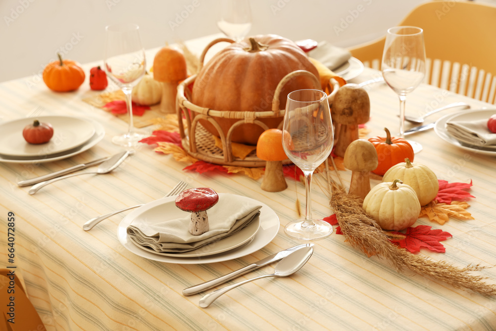 Festive table setting for Thanksgiving Day with pumpkins, leaves and glasses