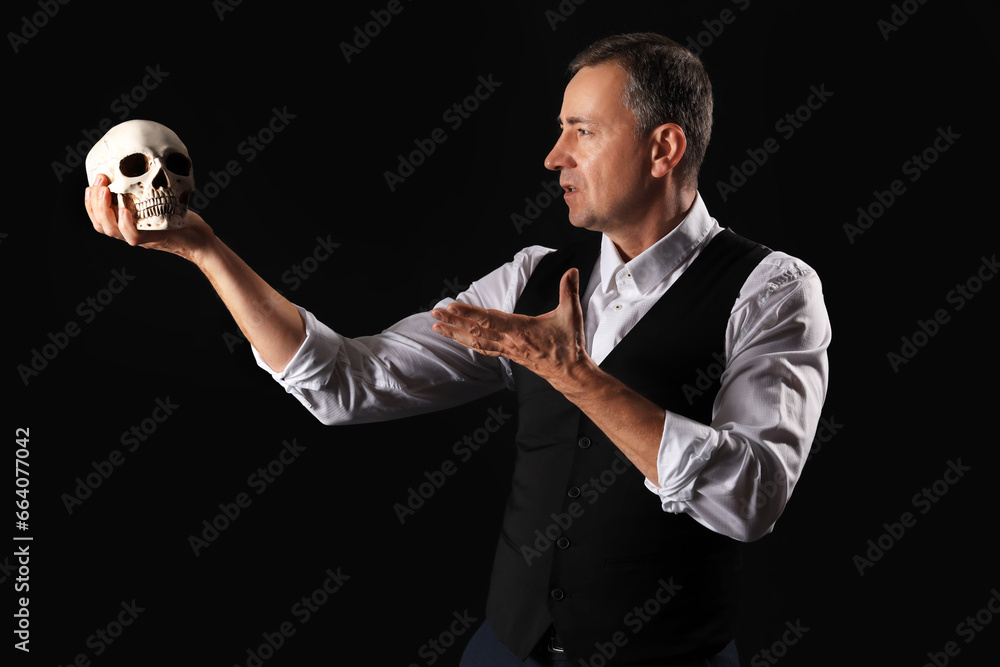 Mature actor with skull on dark background