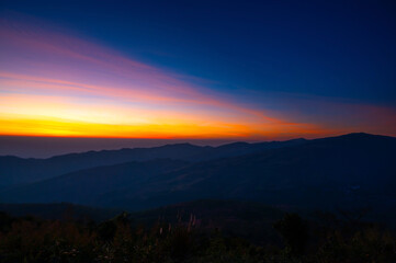 Wall Mural - aerial view sunset , sunrise over dark mountain with fog over the ground.the early evening sun illum