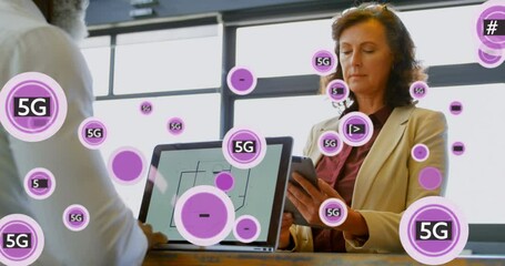 Wall Mural - Animation of 5g and symbols in circles over diverse coworkers using laptop and digital tablet