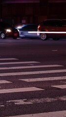 Wall Mural - vertical timelapse low angle view to the asphalt crossing street at intersection area in night time