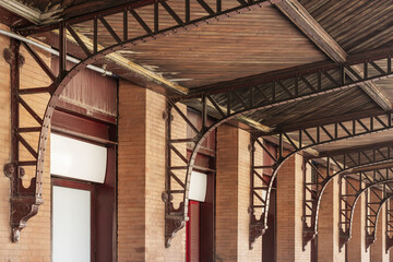 Wall Mural - A wooden ceiling secured with vintage metal brackets to the brick walls