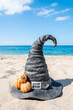 Halloween beach background with witch hat and pumpkins