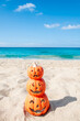 Halloween beach background with three pumpkins