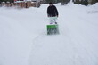 © Liubov - A man cleans snow in the winter in the courtyard of the house,  man cleaning snow with a snow blower