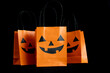 © Longfin Media - Halloween treat bags for trick-or-treating sweets candies. Paper gift bags with handles, for candy and other goodies. Decorated with spooky Jack-o'-lantern face. Trick or Treat party favor bags.