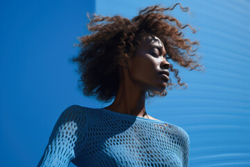 Young African American woman portrait in bright blue color background