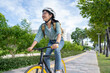 © PBXStudio - Attractive Asian woman in casual clothes and helmet riding a bicycle on a workday in the city