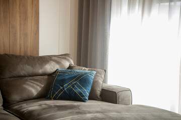 Wall Mural - Grey comfortable sofa with blue cushion next to the big window with lot of natural sunlights