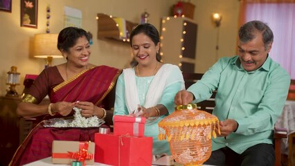 Wall Mural - Happy Indian middle aged parents with daughter busy preparing for diwali festival celebration at home - concept of deepavai decoration, family bonding and holidays.