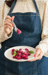 Wall Mural - Italian gnocchi beetroot . Traditional Italian food in a bowl is held by a woman in an apron. Handmade potato balls with parmesan and beets. Food for vegetarians and lovers of Italian typical cuisine 