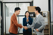 © laddawan - Asian business people shaking hands during a meeting in office.