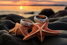 Vintage Wedding Rings Inside A Starfish Shell, Placed On A Coastal Rock At Sunset