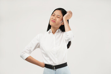 The photo of a young Asian woman feeling unhappy and stressed touching her face, frowning. Indoor studio concept isolated on a white background.
