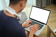 © Prathankarnpap - Man in casual clothes and headphone surfing internet or working online on laptop while sitting on sofa