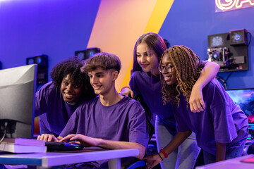 young group of multiracial teenage gamers playing online video games, the team pays attention to the screen and celebrates the victory