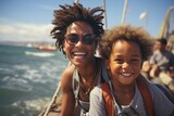 Charming mother and son on the deck of sailing boat moving in sea. Happy traveling African American family enjoying boat trip. Active leisure, family vacation, sports, fun and recreation.