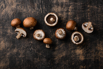 Raw champignon mushrooms on black background