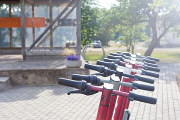 electric scooter on parking slot. urban transportation- row readies to ride bikes with accumulators on the pavement at the park