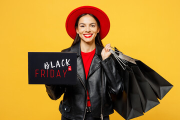Wall Mural - Young smiling fun woman wearing casual clothes red hat hold shopping paper package bags card sign with Black Friday written text inscription isolated on plain yellow background. Sale buy day concept.