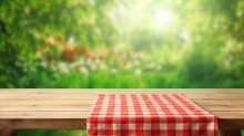 Empty Wooden Desk Table With Red Checkered Tablecloth Over Abstract Bright Light Green Spring Or Summer Background. Template For Your Food And Product Display Montage.