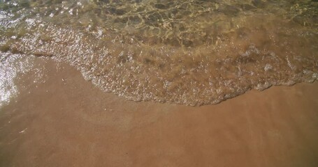 Wall Mural - Sandy Yellow Beach And Calm Sea Ocean Waves. Sea Waves Wash Sandy Shore. White Bubbles Waves. Sea Beach Background. Concept Of Summer Holidays, Walks Along Coast. Copy Space. Waves Hitting Sand Beach.
