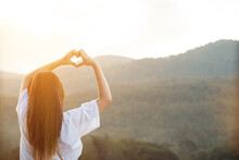 The Young Woman Raised Her Hands Above Her Head And Made A Heart Shaped Sign To Show Friendship Love And Kindness Towards One Another. The Concept Of Friendship Love Between Friends And Kindness