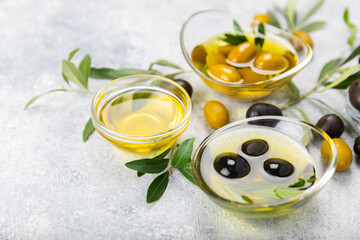 Olive oil in a bottle on texture background. Oil bottle with branches and fruits of olives. Place for text. copy space. cooking oil and salad dressing.