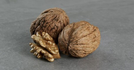 Wall Mural - Walnuts on a gray background. Close-up footage on the rotating table.