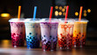 Closeup of a colorful assortment of bubble / boba milk tea cocktail drinks on a table