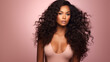beautiful black african american model with curly long hair  with clean healthy skin  on pink background with copy space