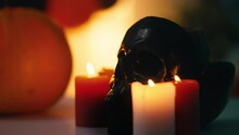 Burning Candles Standing Near Decorative Black Skull Creepy Halloween Atmosphere