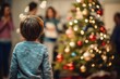 Child with their backs looking at the Christmas tree and family in the background. Concept of Christmas day or three wise men day.