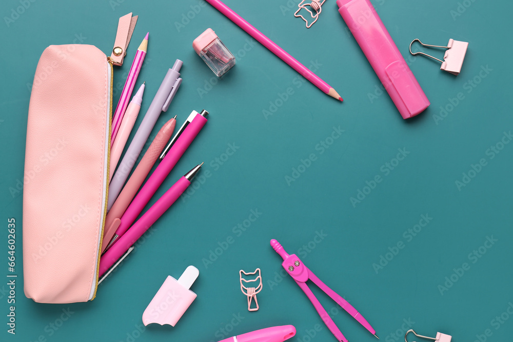 Pink pencil case with school stationery on green background