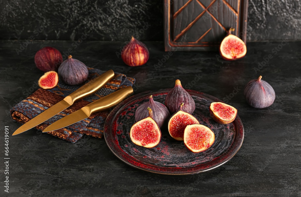 Plate with fresh ripe figs on black background