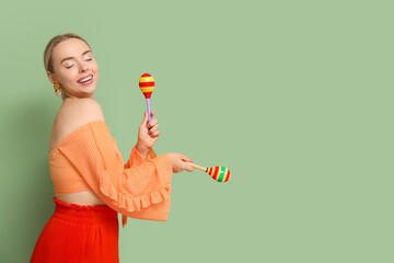 Canvas Print - Pretty young woman with maracas on green background